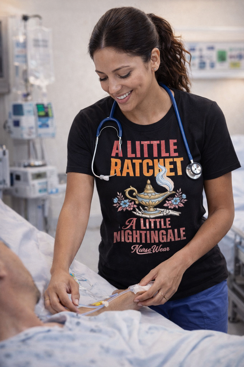 Nurse wearing black A Little Ratchet A Little Nightingale graphic tee while caring for a patient in hospital room with blue scrubs and stethoscope
