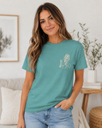 Woman wearing a teal t-shirt with a graphic design in a home setting